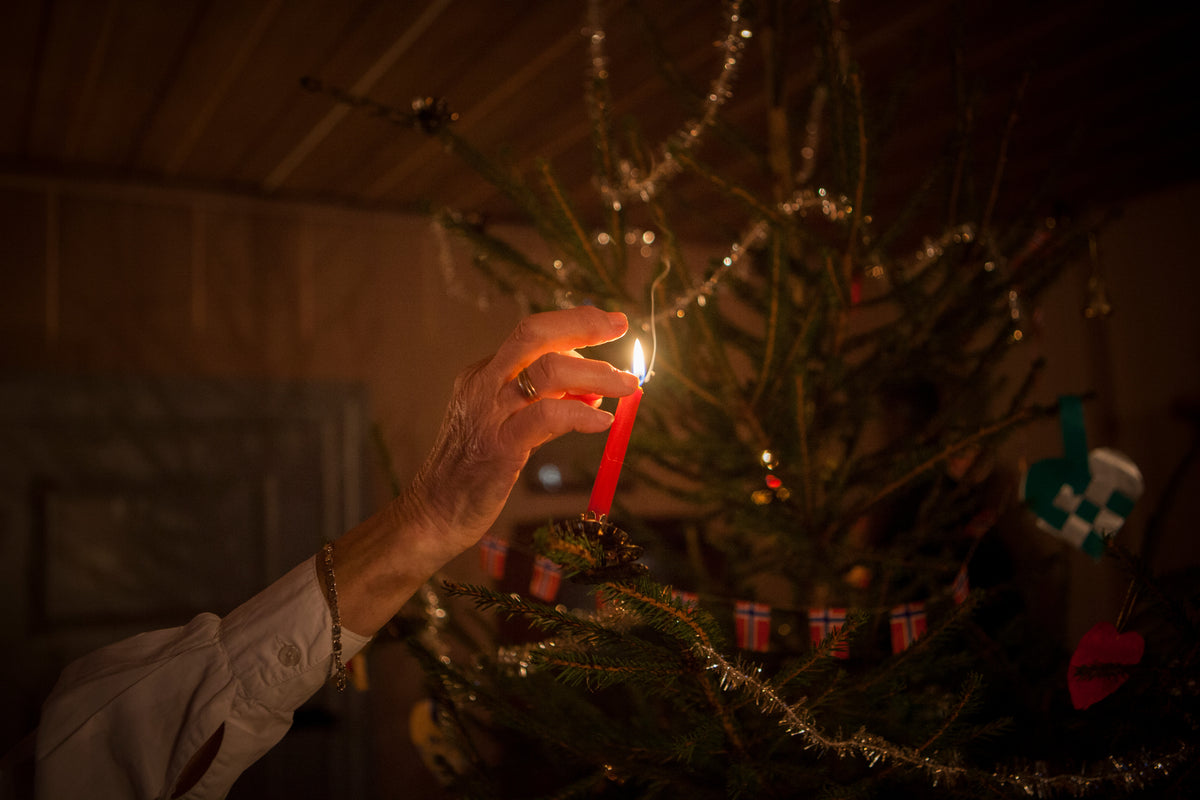 Hånd tenner jul på juletre